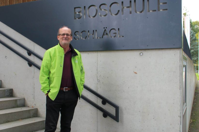 Direktor vor Schulschild